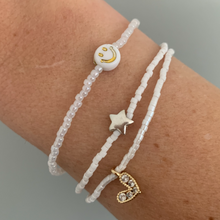 Load image into Gallery viewer, white luster seed bead bracelet with a gold plated heart charm with clear cz crystal stones