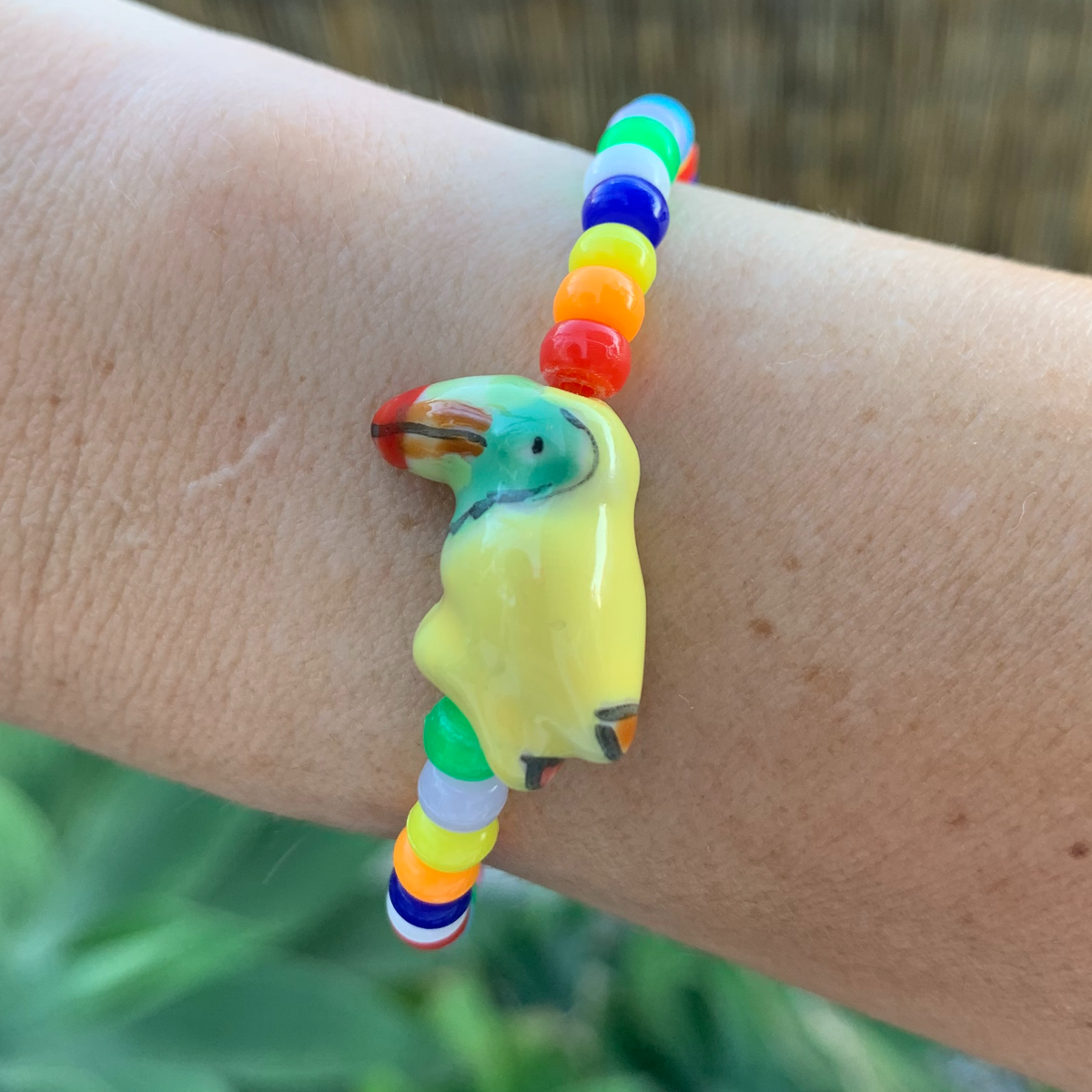 multi colored mini pony bead bracelet with ceramic toucan bead
