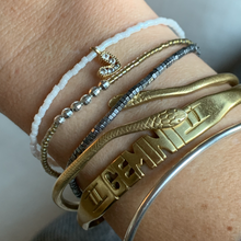 Load image into Gallery viewer, white seed bead bracelet with a gold plated heart charm with clear cz crystal stones