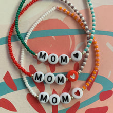 Load image into Gallery viewer, multi colored and patterned seed bead bracelet with MOM, gold beads and a heard bead
