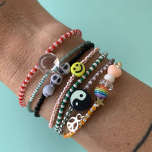 Load image into Gallery viewer, purple, luster white and yellow with red stripes seed bead bracelet with iridescent, shell, peach heart and sterling silver stardust beads with a sterling silver peace sign charm