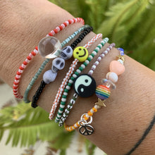 Load image into Gallery viewer, purple, luster white and yellow with red stripes seed bead bracelet with iridescent, shell, peach heart and sterling silver stardust beads with a sterling silver peace sign charm