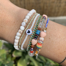 Load image into Gallery viewer, purple, luster white and yellow with red stripes seed bead bracelet with iridescent, shell, peach heart and sterling silver stardust beads with a sterling silver peace sign charm