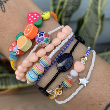 Load image into Gallery viewer, purple, luster white and yellow with red stripes seed bead bracelet with iridescent, shell, peach heart and sterling silver stardust beads with a sterling silver peace sign charm