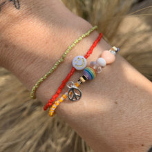 Load image into Gallery viewer, purple, luster white and yellow with red stripes seed bead bracelet with iridescent, shell, peach heart and sterling silver stardust beads with a sterling silver peace sign charm