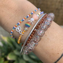 Load image into Gallery viewer, purple, luster white and yellow with red stripes seed bead bracelet with iridescent, shell, peach heart and sterling silver stardust beads with a sterling silver peace sign charm