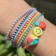 Load image into Gallery viewer, blue, white and red patterned seed bead bracelet with a strawberry, smiley face and multi colored heart bead and rainbow seed bead bracelets
