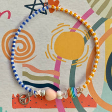 Load image into Gallery viewer, purple, luster white and yellow with red stripes seed bead bracelet with iridescent, shell, peach heart and sterling silver stardust beads with a sterling silver peace sign charm