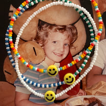 Load image into Gallery viewer, ted lasso multi colored, patterned seed bead bracelet with a yellow smiley face bead
