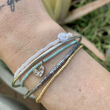 Load image into Gallery viewer, multi colored seed bead bracelet with a gold plated heart charm with clear cz crystal stones