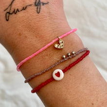 Load image into Gallery viewer, neon pink seed bead bracelet with a gold plated heart charm with clear cz crystal stones