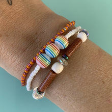 Load image into Gallery viewer, white seed bead bracelet with three multi colored striped beach ball beads
