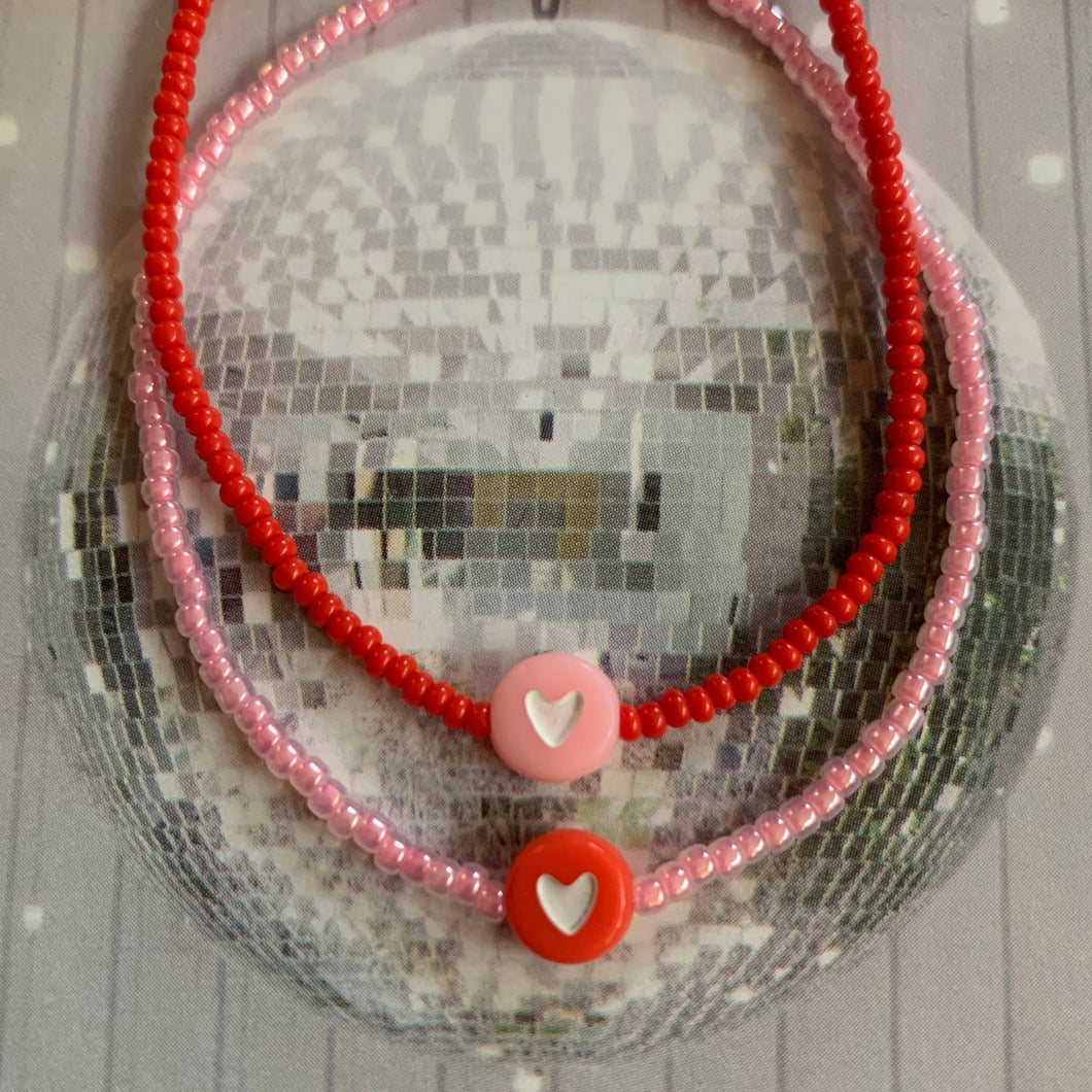 neon pink seed bead bracelet with red heart bead. red seed bead bracelet with pink heart bead
