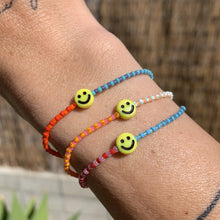 Load image into Gallery viewer, multi colored and patterned seed bead bracelet with a yellow smiley face bead

