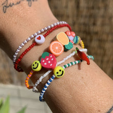 Load image into Gallery viewer, multi colored, patterned seed bead bracelet with a yellow smiley face bead, fruit beads
