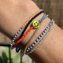 Load image into Gallery viewer, orange, red, blue, purple patterned seed bead bracelet with a yellow smiley face bead

