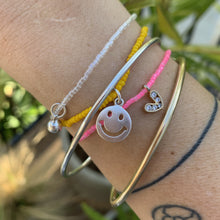 Load image into Gallery viewer, neon pink seed bead bracelet with a gold plated heart charm with clear cz crystal stones, sterling silver smiley face and jingle bell bracelets
