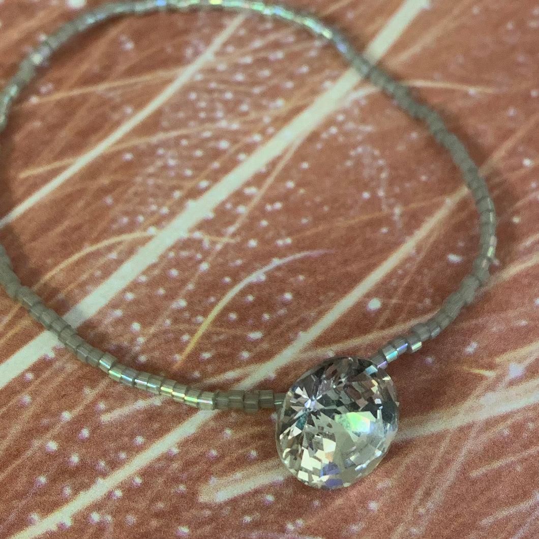 grey luster iridescent seed bead bracelet with a rhinestone button bead