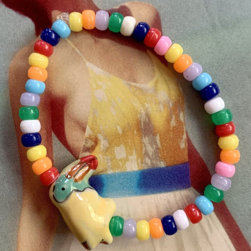 multi colored mini pony bead bracelet with a ceramic toucan bead