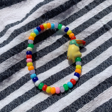 Load image into Gallery viewer, multi colored mini pony bead bracelet with a ceramic toucan bead
